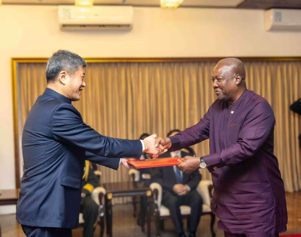 Çin Büyükelçisi Cong Song, Gana Cumhurbaşkanı John Mahama'ya güven mektubu sunuyor.