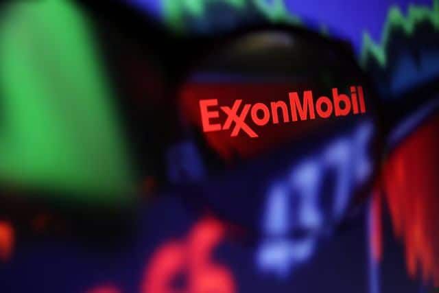 Exxon Mobil logosu ve hisse senedi grafiği büyüteçle görülüyor