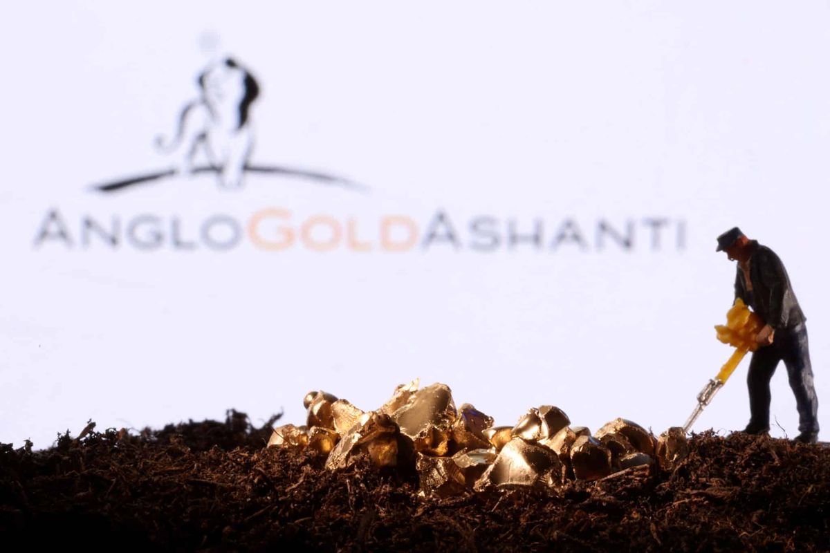 AngloGold Ashanti logosu önünde oyuncak figür ve altın taklidi