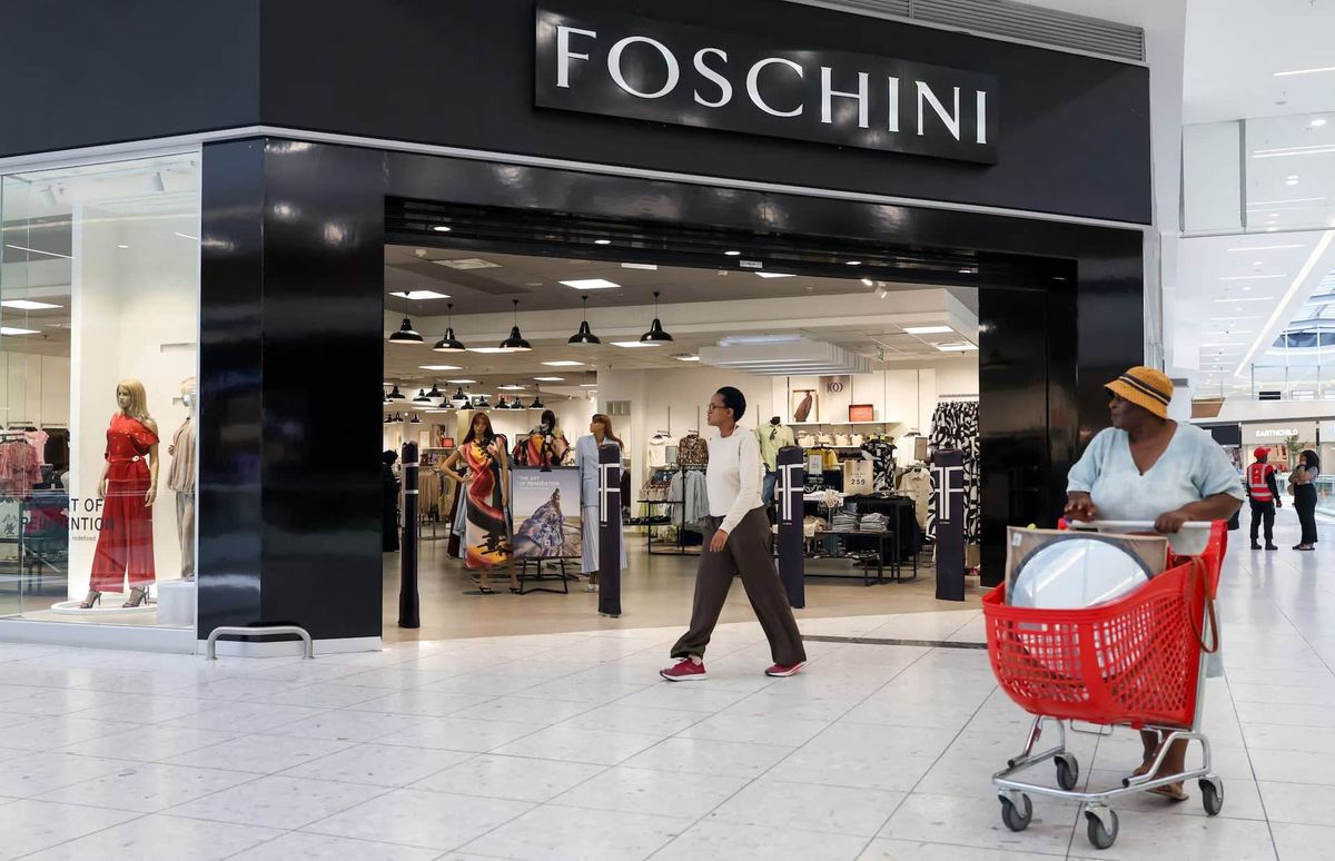 Johannesburg, Güney Afrika'da bir alışveriş merkezindeki Foschini mağazası önünde yürüyen müşteriler